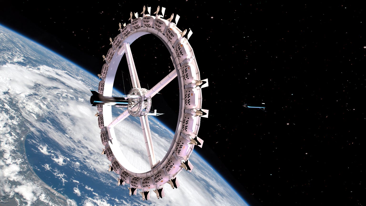 The image appears to show a futuristic space station, possibly a conceptual rendering of the Voyager Station. The station is a large circular structure resembling a wheel, suspended in space with a starry backdrop. The design includes numerous segments and spokes connecting the central hub to the outer ring, evoking a sense of rotation and artificial gravity. The lighting and metallic details suggest advanced technology and a focus on human habitation or exploration in space.